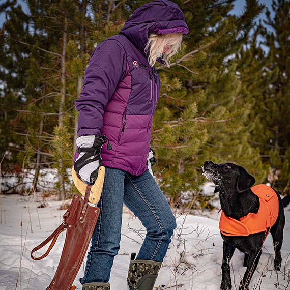 Jody's wife walking through the snow in her Muck boots with one of their dogs.