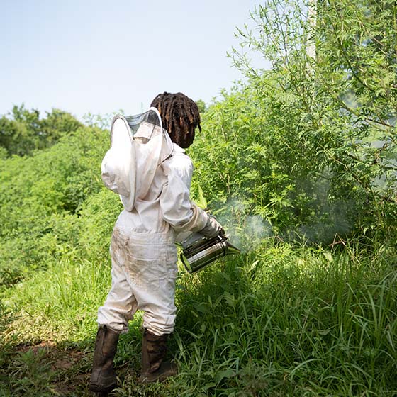 One of the children, learning about bee keeping while working on the farm