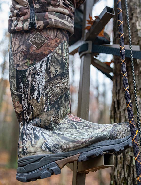 allie climbing a tree stand wearing her Muck boots