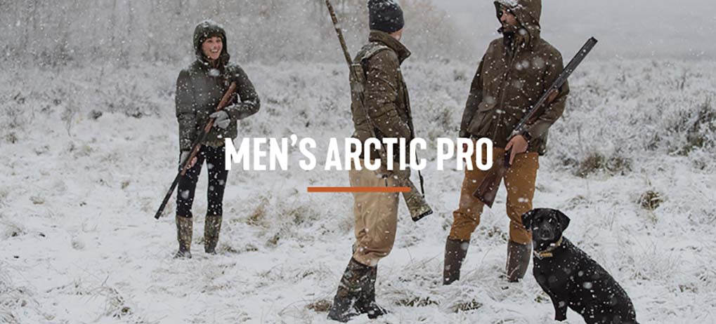 'Men's Arctic Pro' Three hunters and a dog stand in heavy snow, carrying their guns, and wearing their Muck Arctic Pro boots.