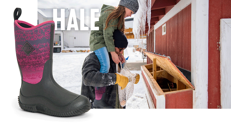 Father carrying daughter on his shoulders in front of a snowy barn. Icicles dangle from the edge of the barn roof.