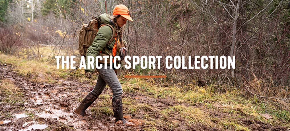 'The Arctic Sport Collection' Woman hiking in the forest, bundled up in the cold weather, and walking through thick mud with her Arctic Sport Muck boots.