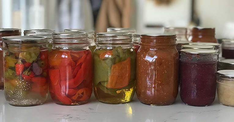 Mason Jars lined on a counter containing all different fruits and vegetables