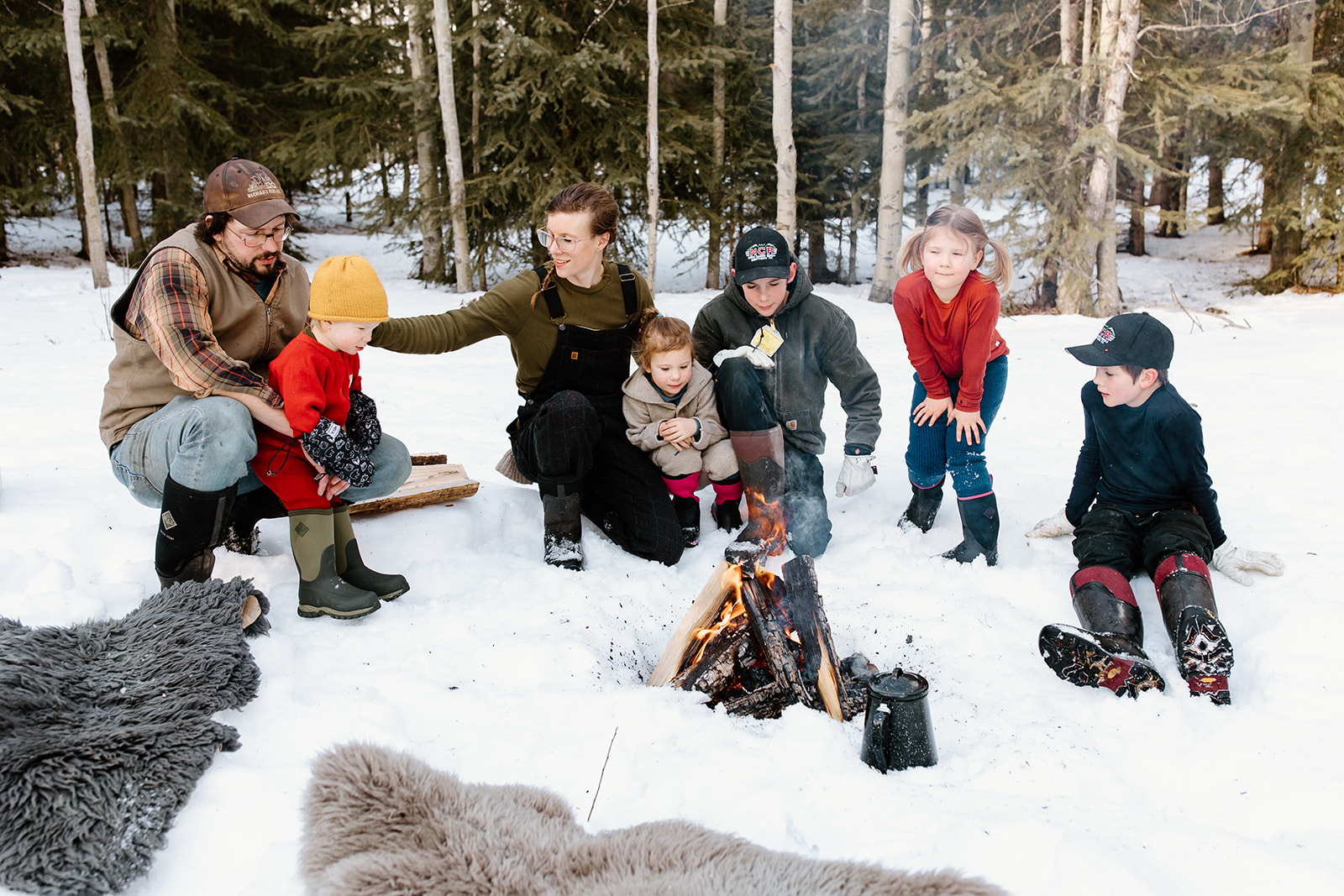 Kate Schat and family sit around a snowy campfire.