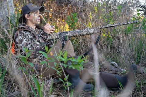 Angelique in camo sitting against a tree