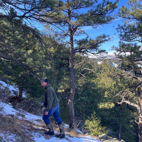 Brayden walking through the snow covered woods with his Muck boots.