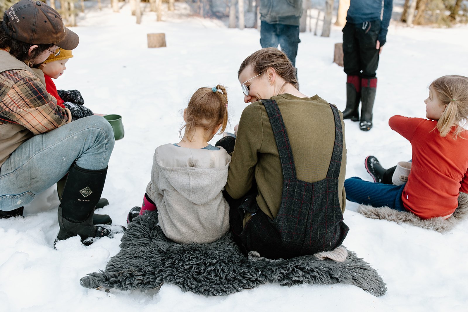 Kate Schat and family sitting in a half circle in the snow.