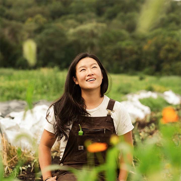 A girl standing and smiling in a field