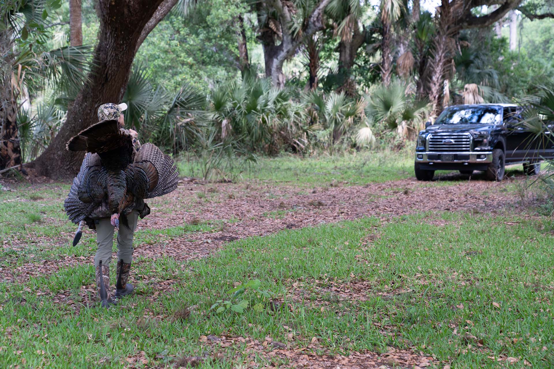 Allie walking towards truck carrying turkey on her back