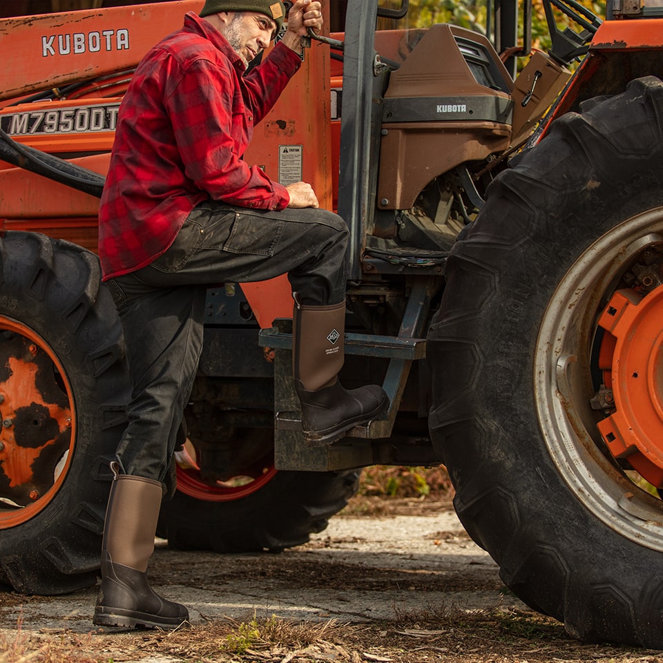 Farmer standing next to plow wearing Muck Chore Classic Tall XpressCool